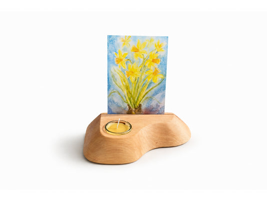 Wooden candle and postcard holder with a floral card on a white background