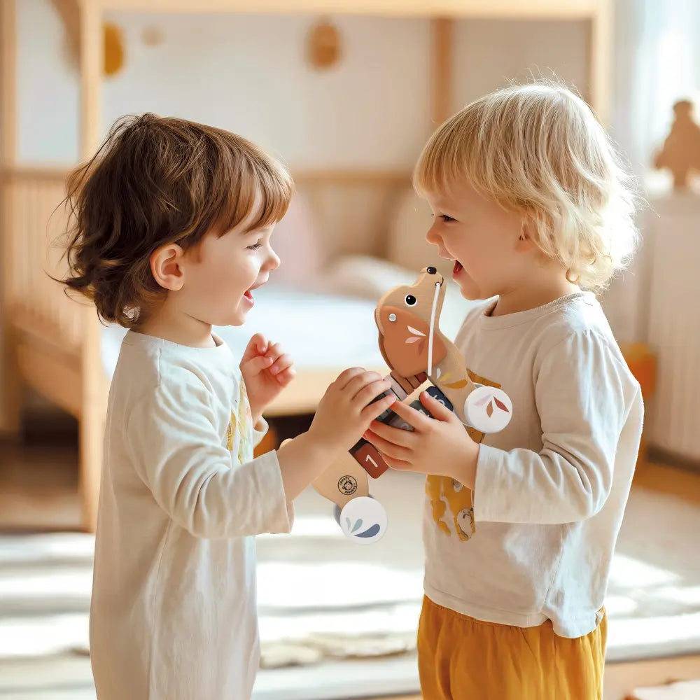 Young children holding and playing with wooden puppy pull along toy