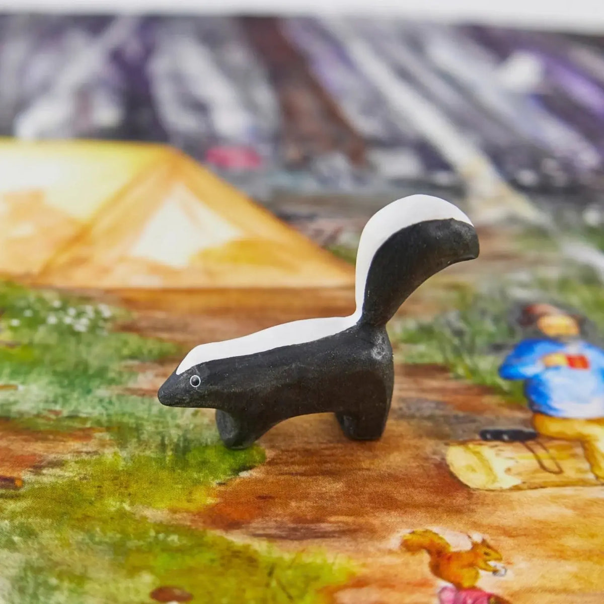 Sarah’s Silks wooden skunk toy in a woodland camping small-world play scene