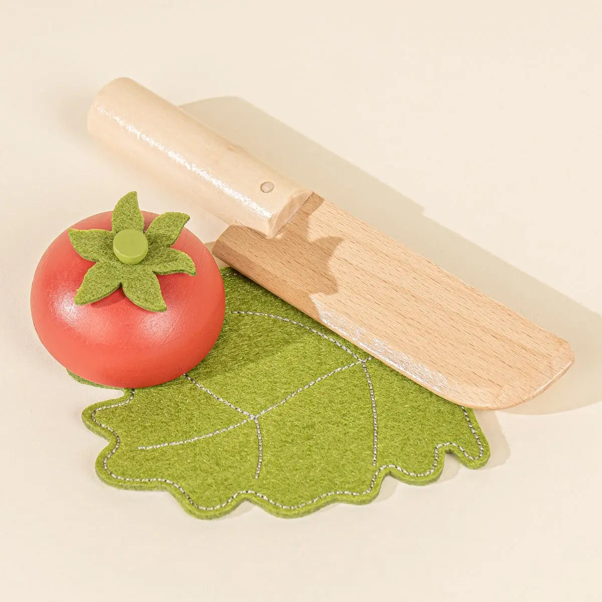 Wooden tomato and lettuce with toy knife