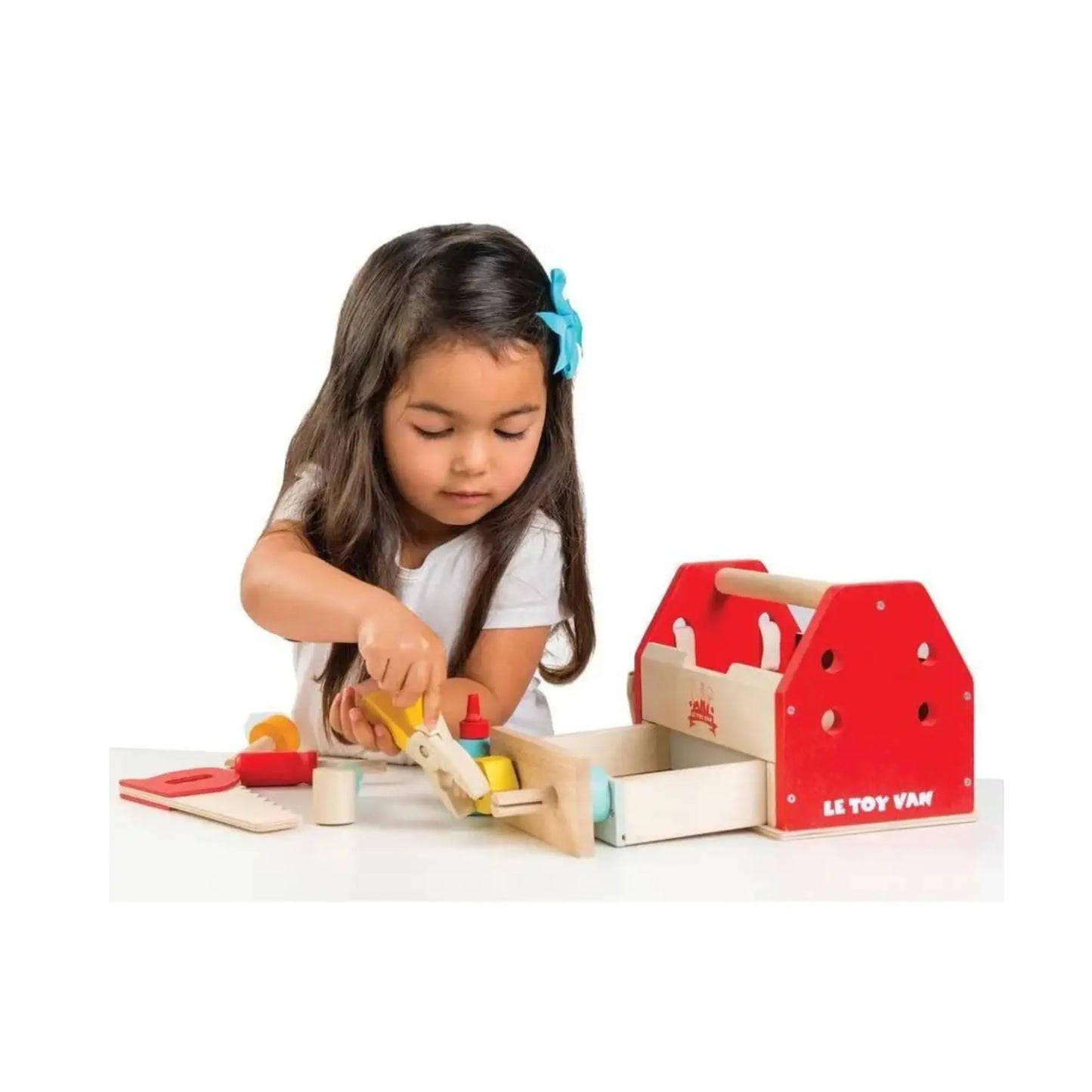 Child playing with a red toy toolbox on a white background