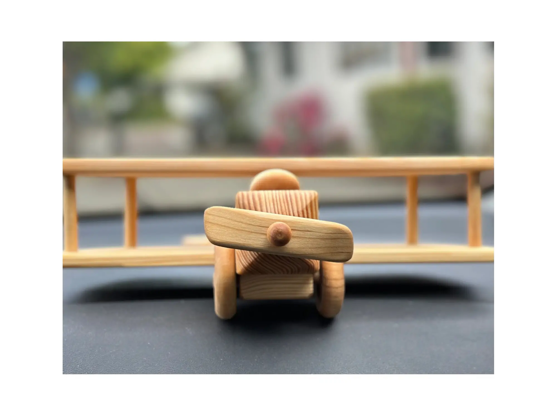 Front view of wooden toy airplane showing propeller detail and smooth natural wood finish