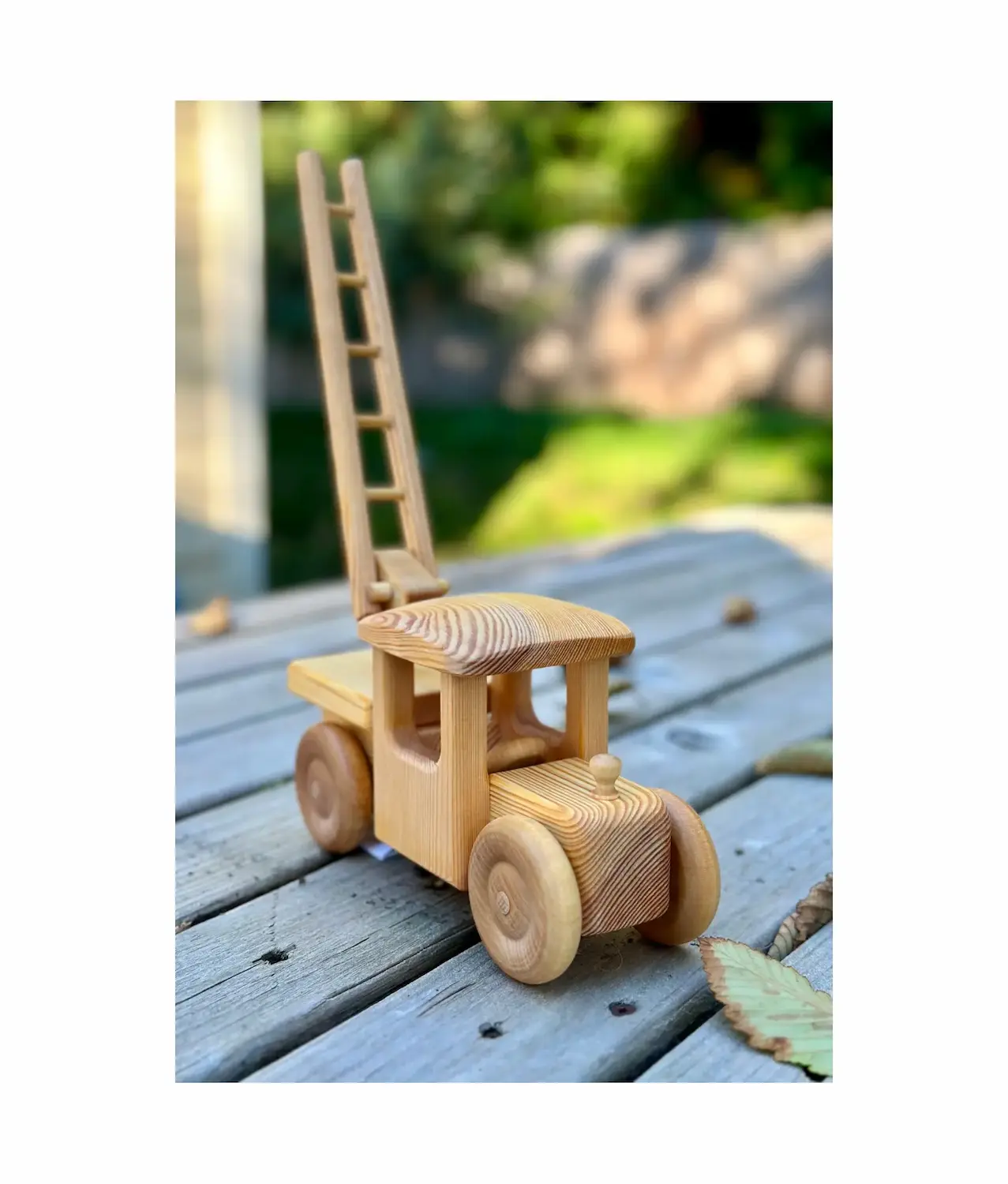 Wooden toy firetruck with ladder raised showing extendable ladder feature and craftsmanship