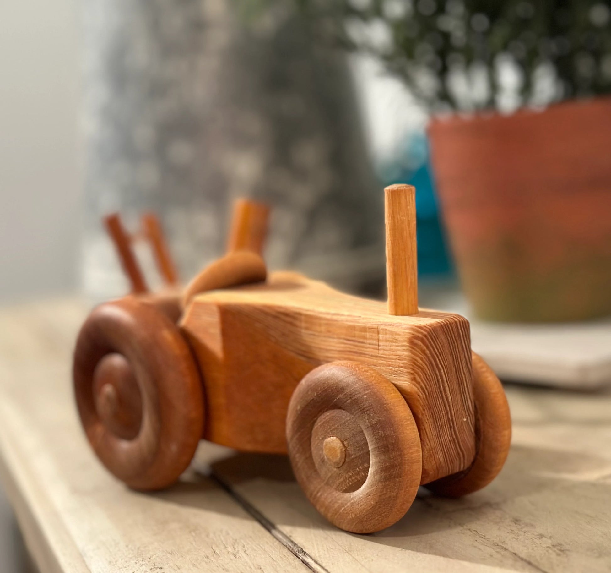 Close-up of wooden toy tractor showing wheel detail and natural wood grain