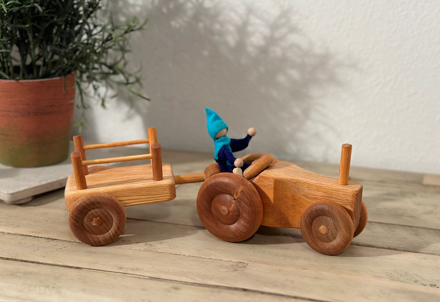 Side view of wooden toy tractor and trailer set for hauling and imaginative play