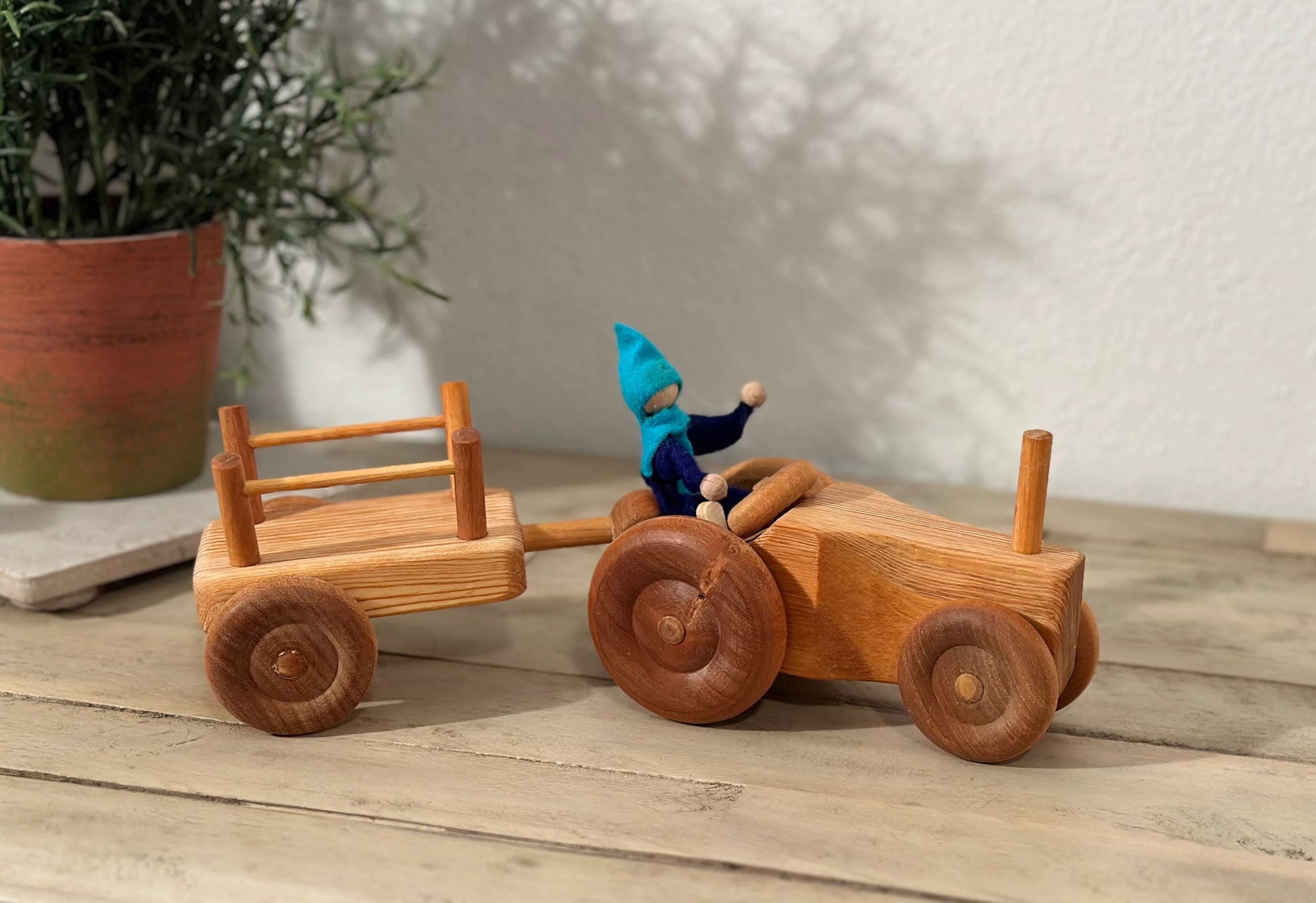 Side view of wooden toy tractor and trailer set for hauling and imaginative play