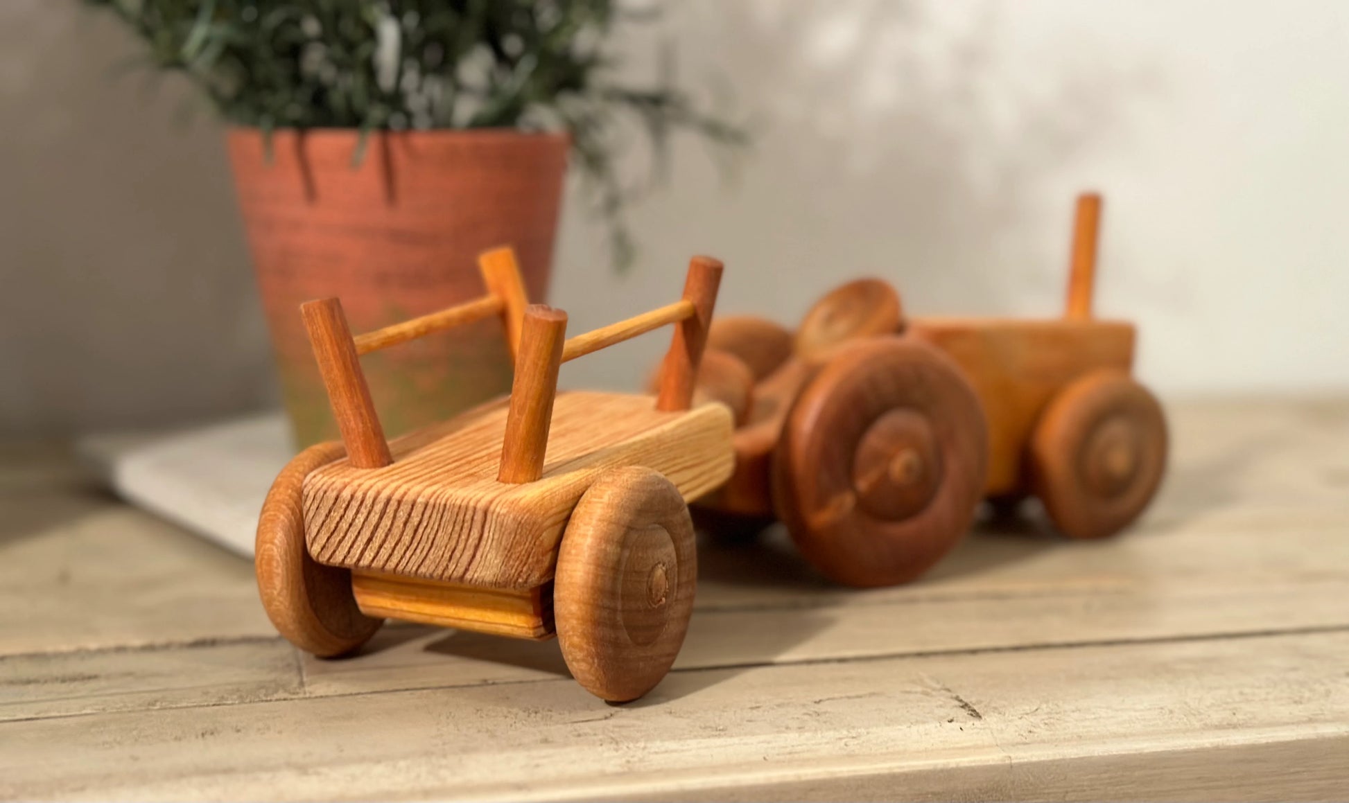Wooden toy trailer attached to tractor in a play scene for hauling and transport play