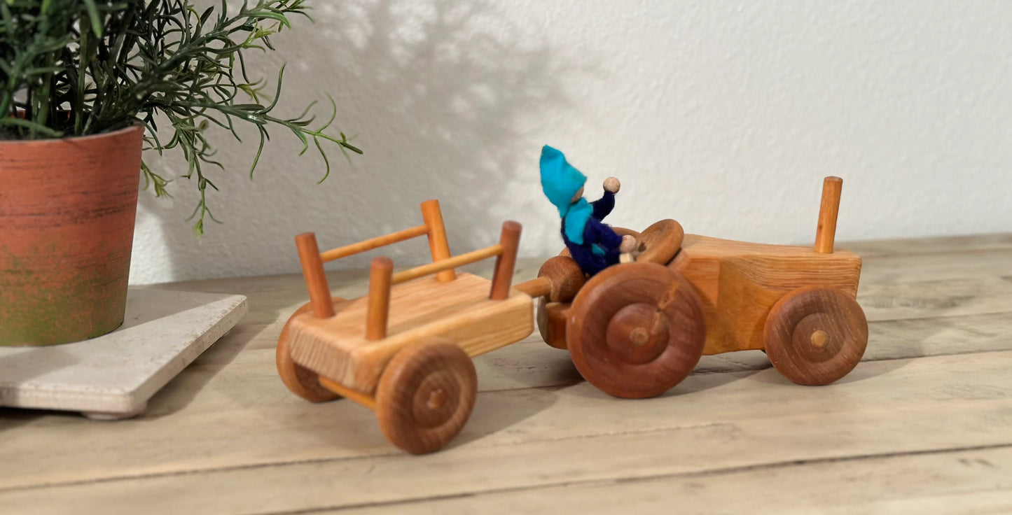 Wooden tractor with trailer in a natural play scene for storytelling and open-ended play