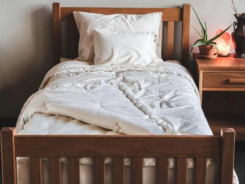 Organic wool comforter on bed showing quilted eco wool fill and natural cotton shell in bedroom setting