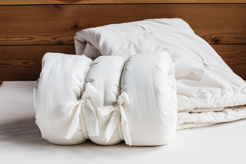 Rolled wool comforter tied in bundle showing dense eco wool fill and structure