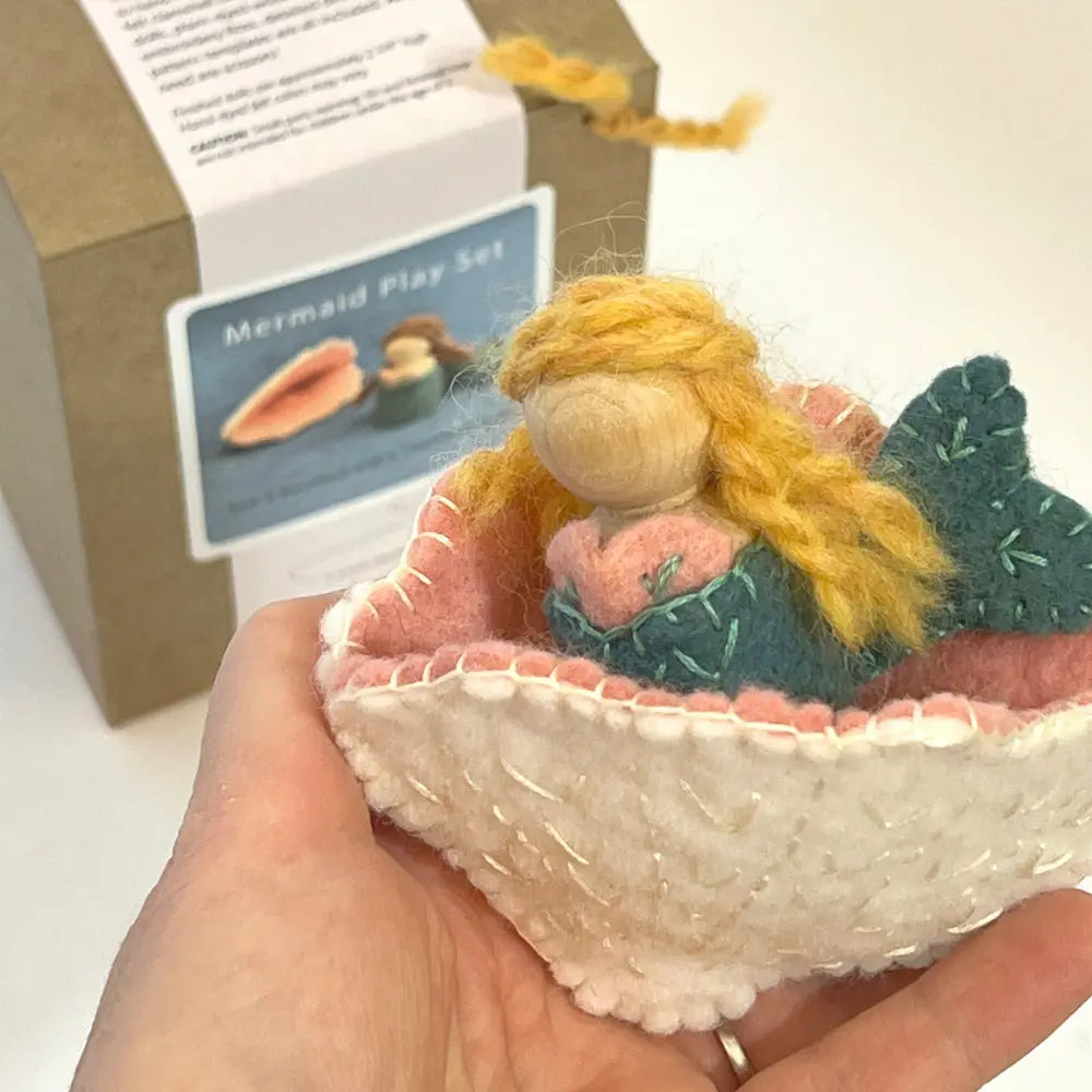 Mermaid wool and peg doll craft set with a doll and shell in a hand, with packaging