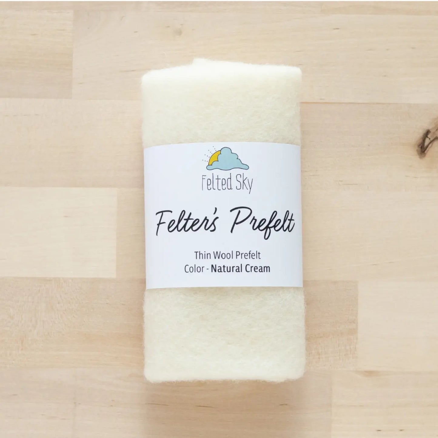 Cream wool Felter's Prefelt for wool paintings and dying on wood background with branded label