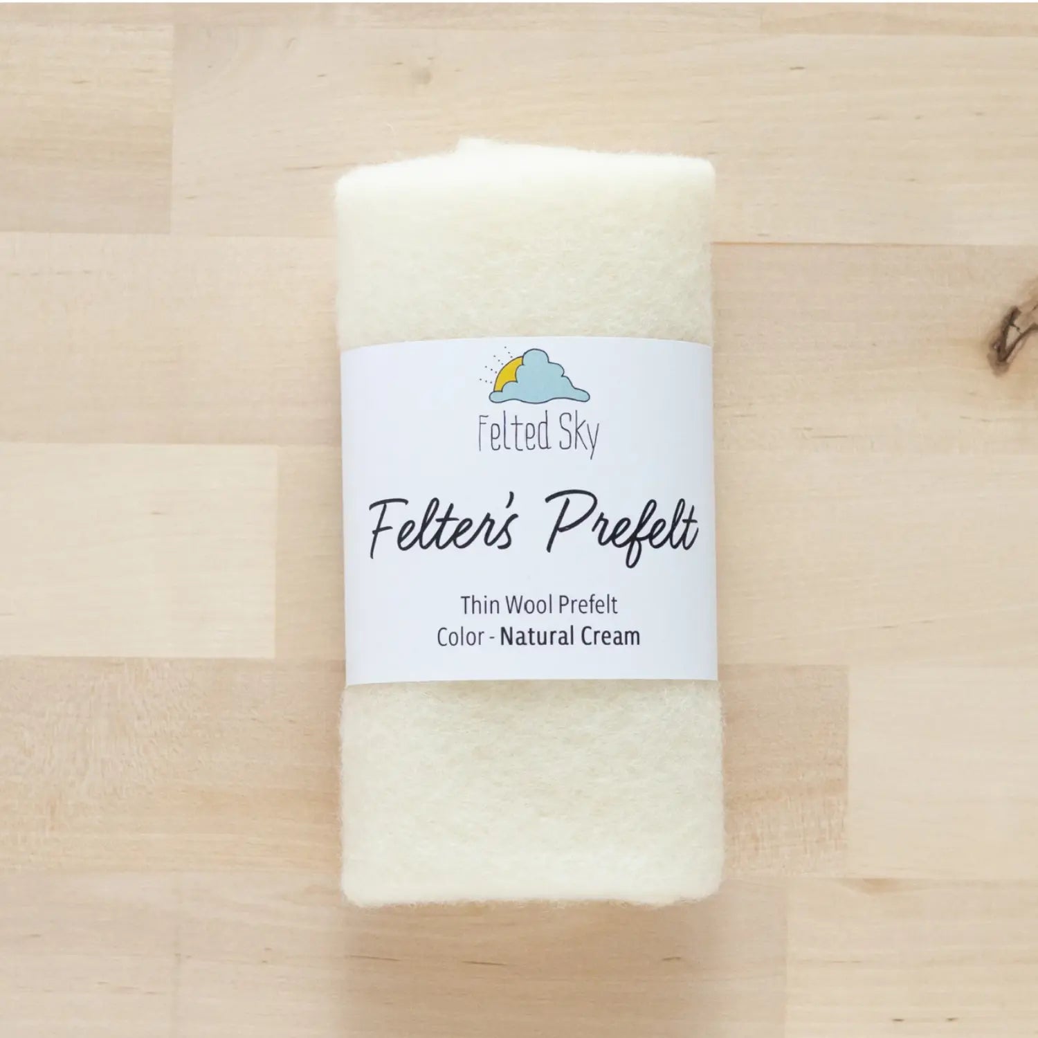 Cream wool Felter's Prefelt for wool paintings and dying on wood background with branded label