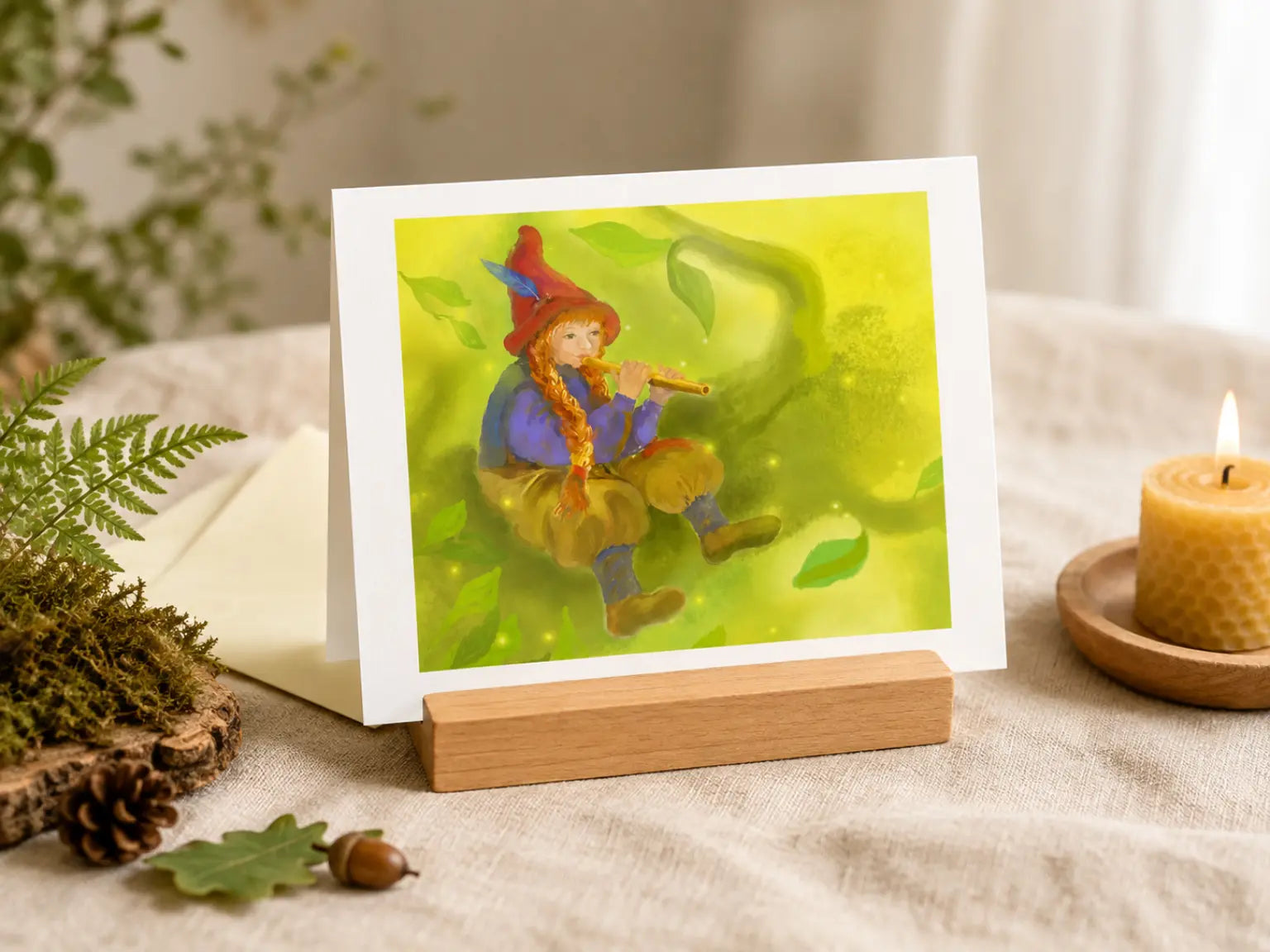 A landscape style art notecard of a girl gnome playing a flute on a tree branch set up as a display