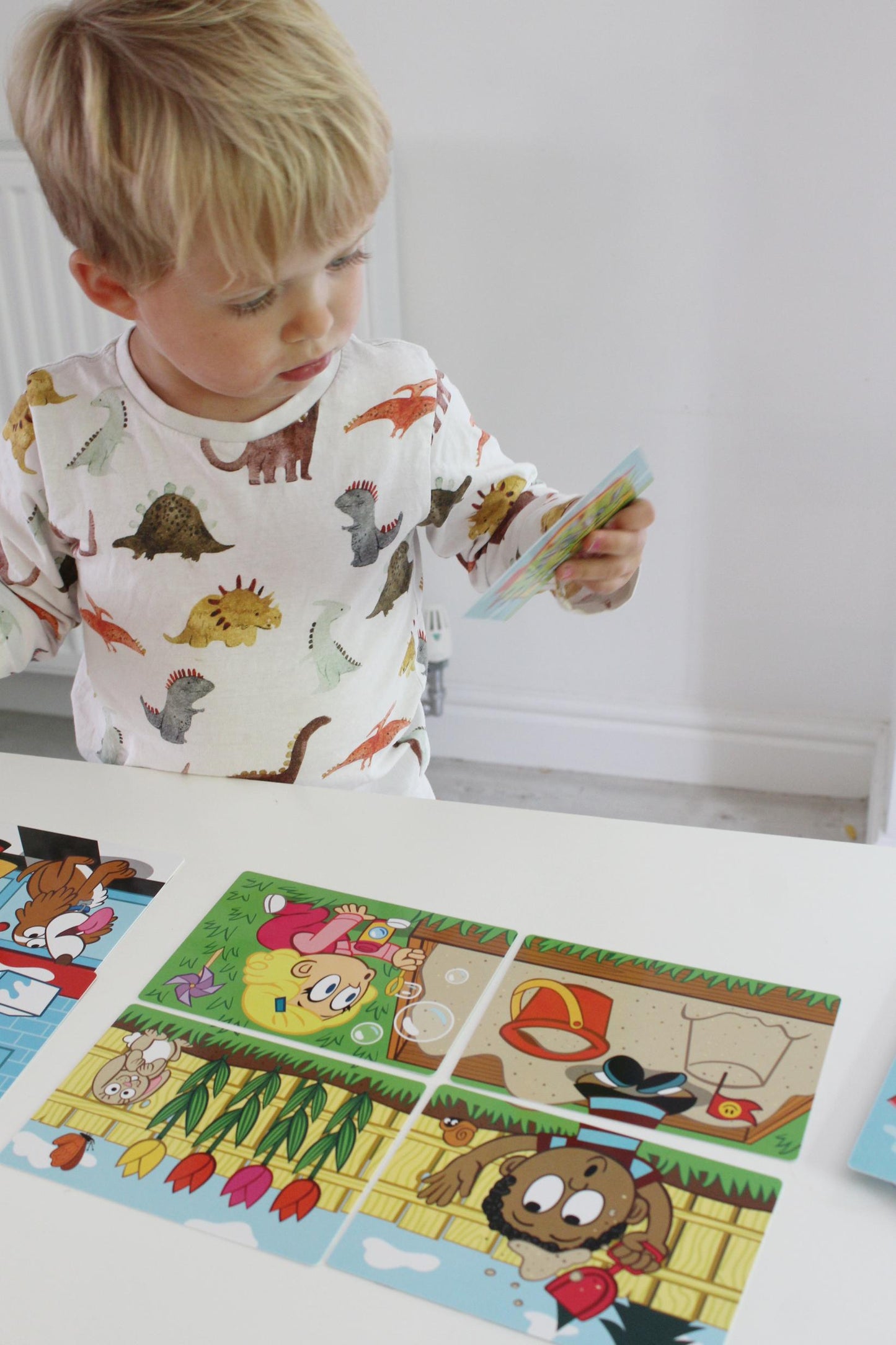 Preschooler playing Uh Oh on a white table top