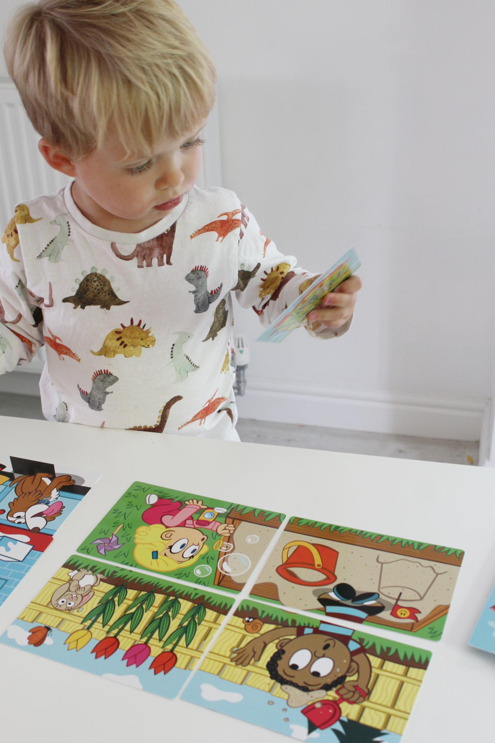 Preschooler playing Uh Oh on a white table top