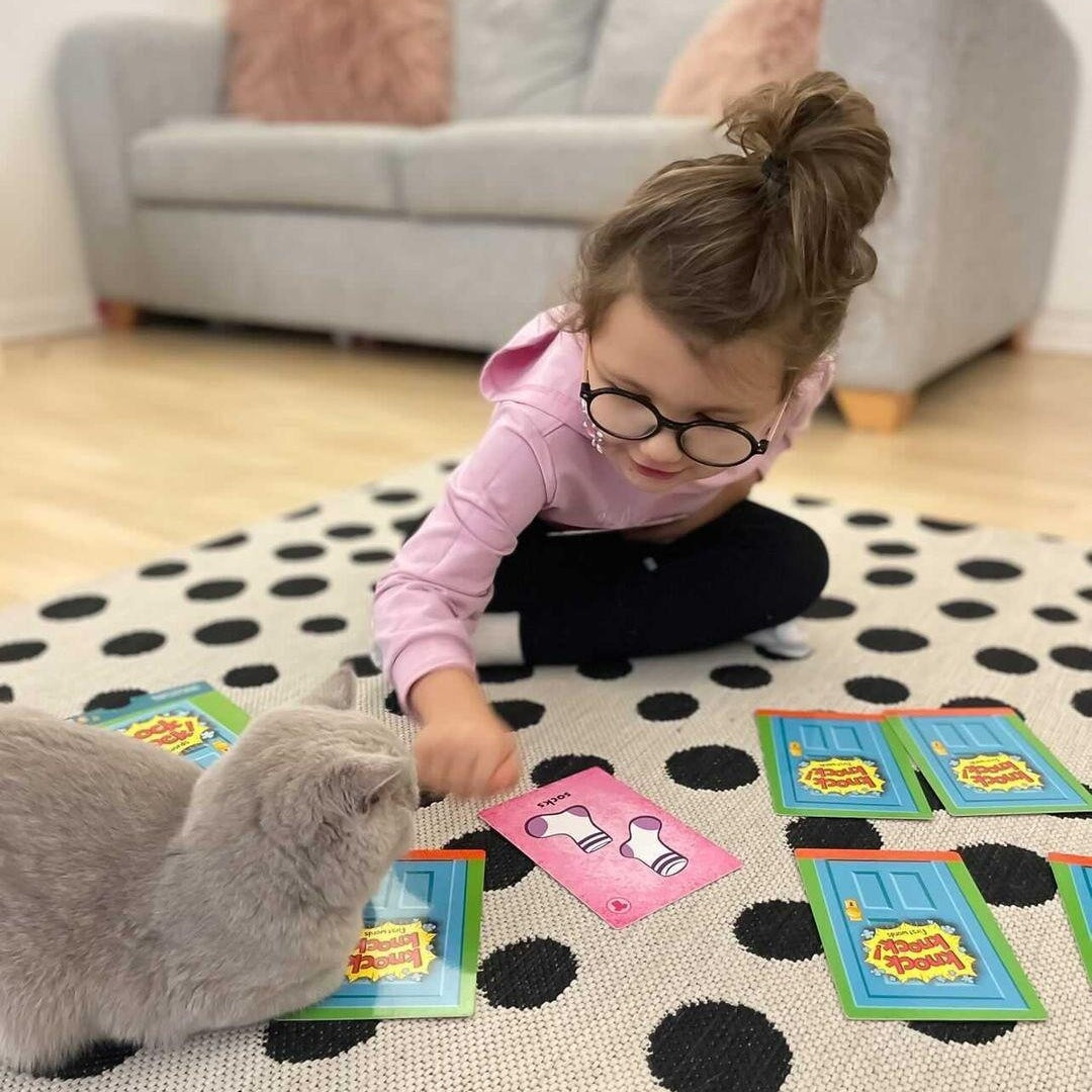 A Preschooler playing Knock Knock card game on a white table