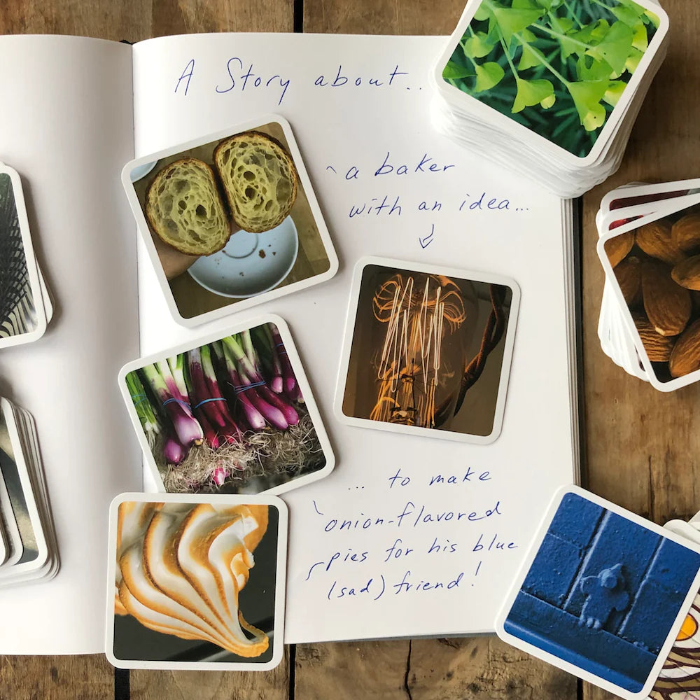 OuiSi photo cards stacked on wooden surface with notebook nearby