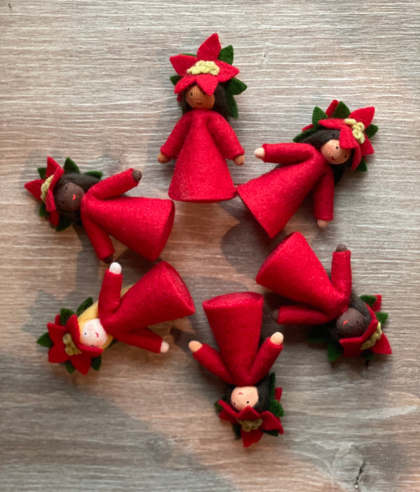 Six Poinsettia Flower Fairy Dolls on a wood background
