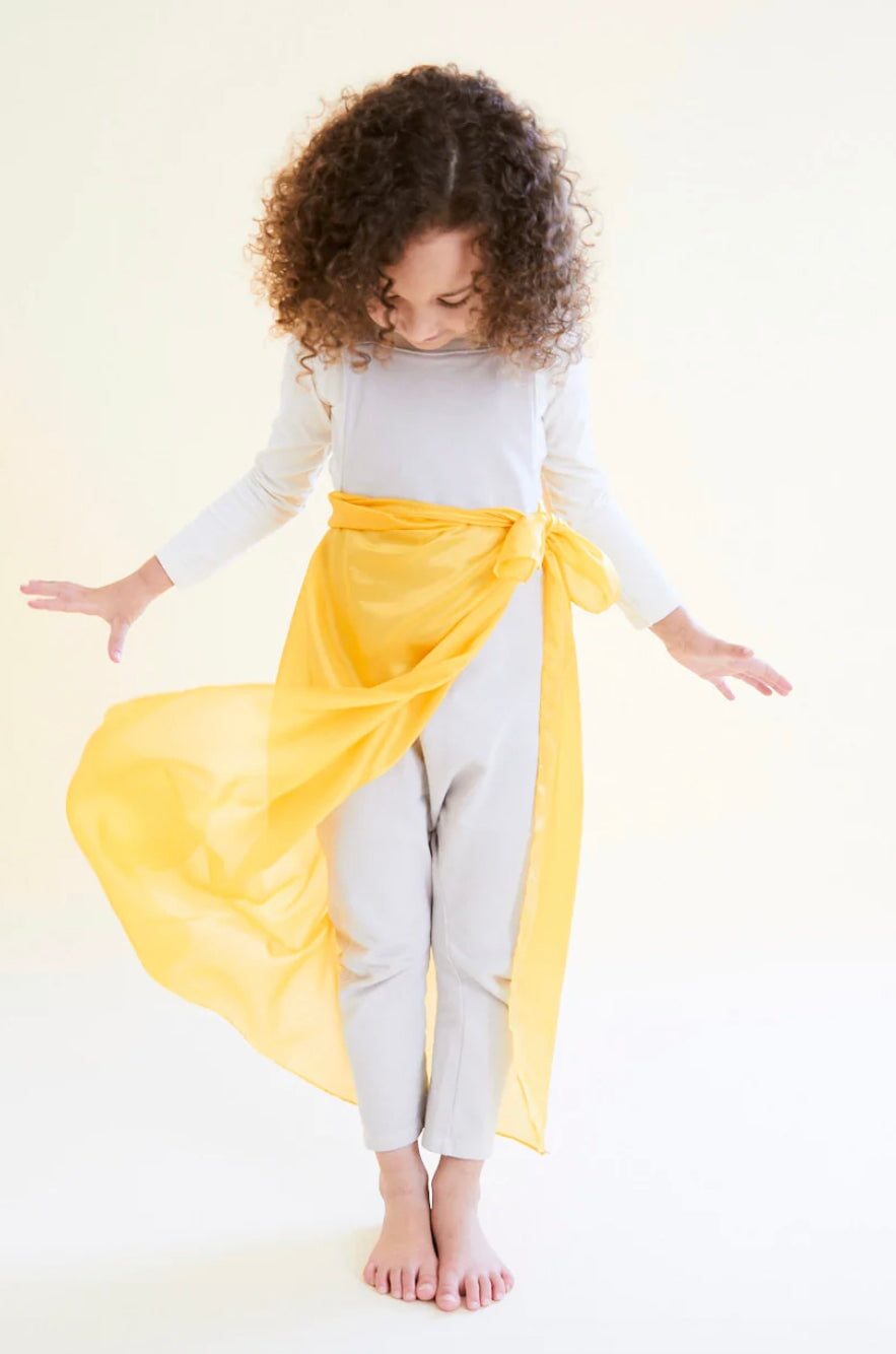 a girl with a golden yellow playsilk tied around her waist