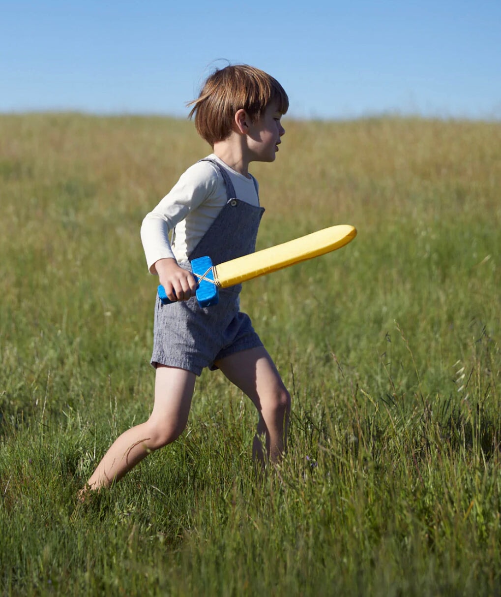 Child in a Grassy Meadow playing with a Soft Sword - Silk + Foam