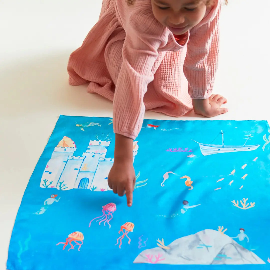 A child playing with the Under the Sea Playsilk