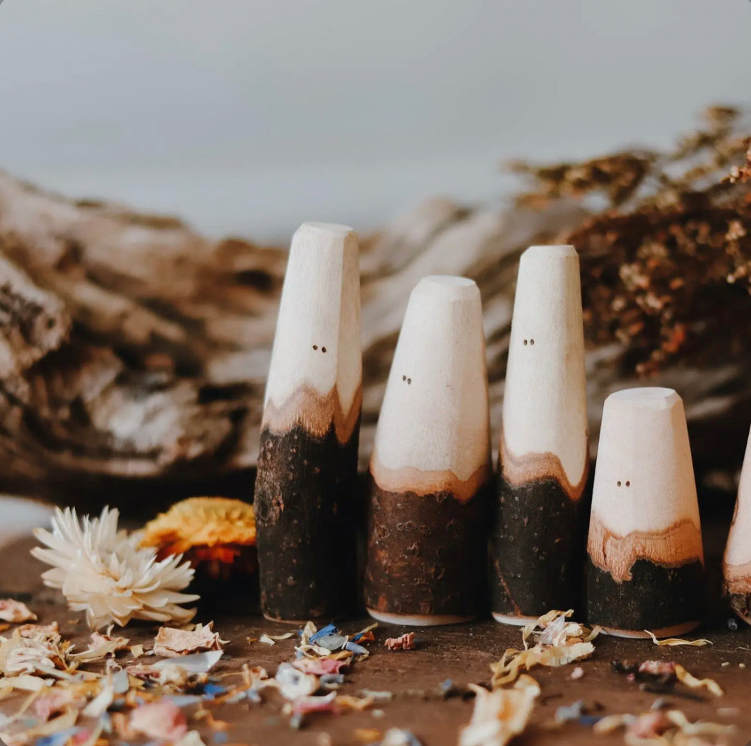Wooden Tree People figures arranged with natural materials for nature table play