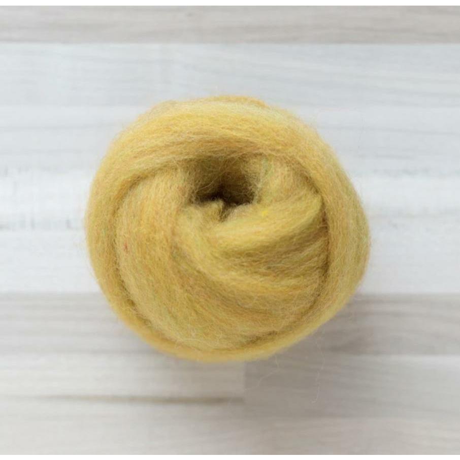 knot of wool roving in butterscotch yellow for needle felting on wooden background