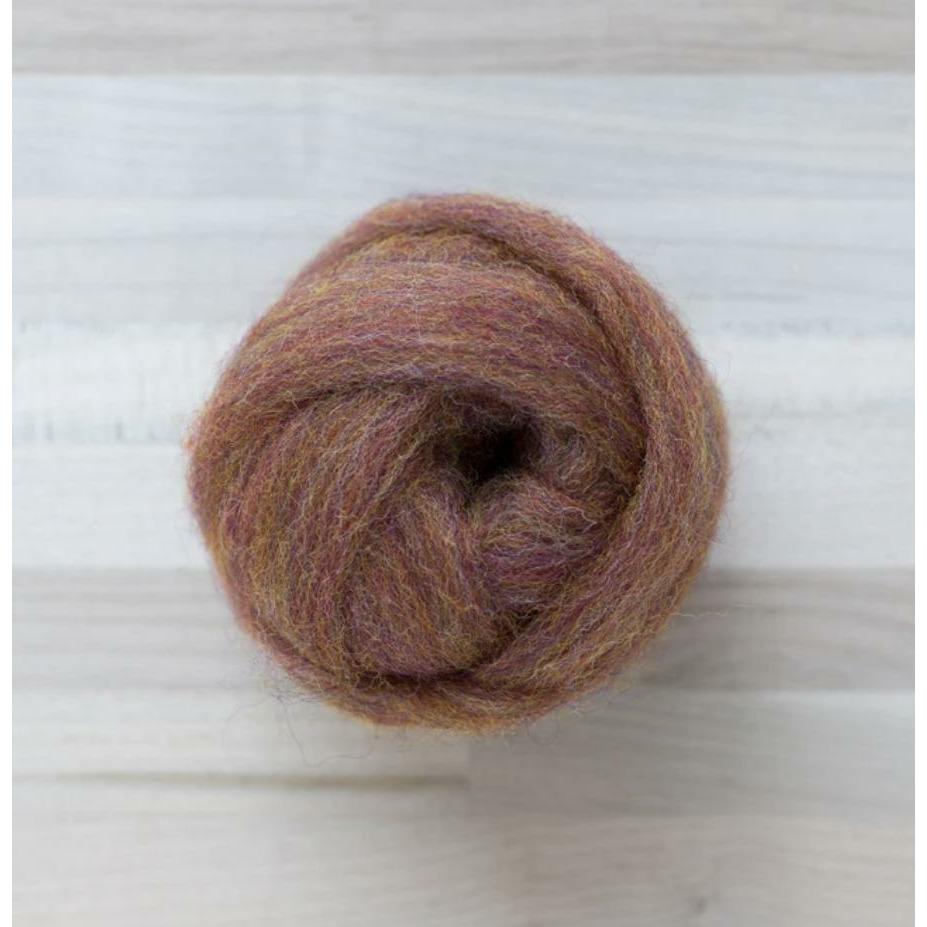 knot of wool roving in multidimensional reddish brown called little fox on wooden background