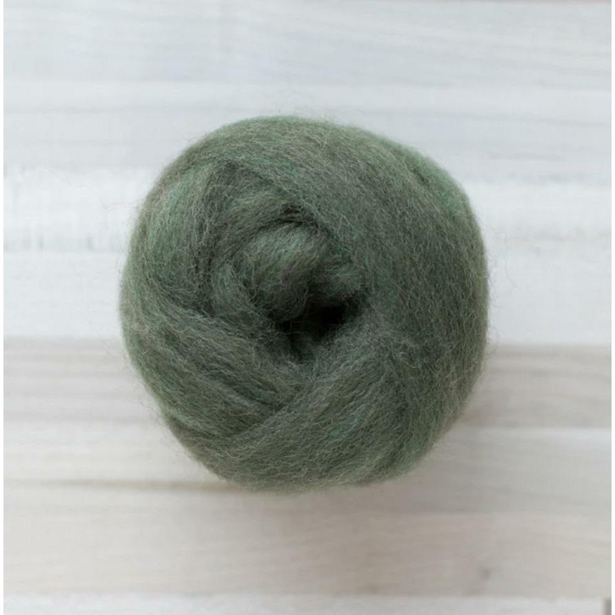 knot of wool roving in woodland green for needle felting crafts on wooden background